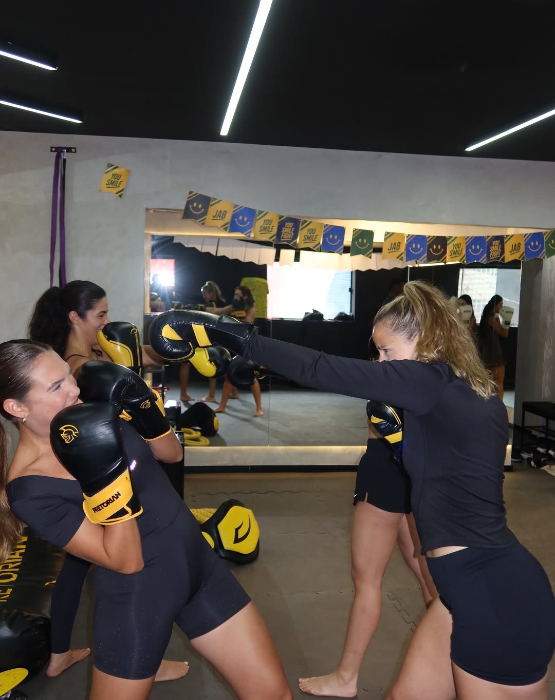 Aluna golpeando o mitt com a professora na YOU
